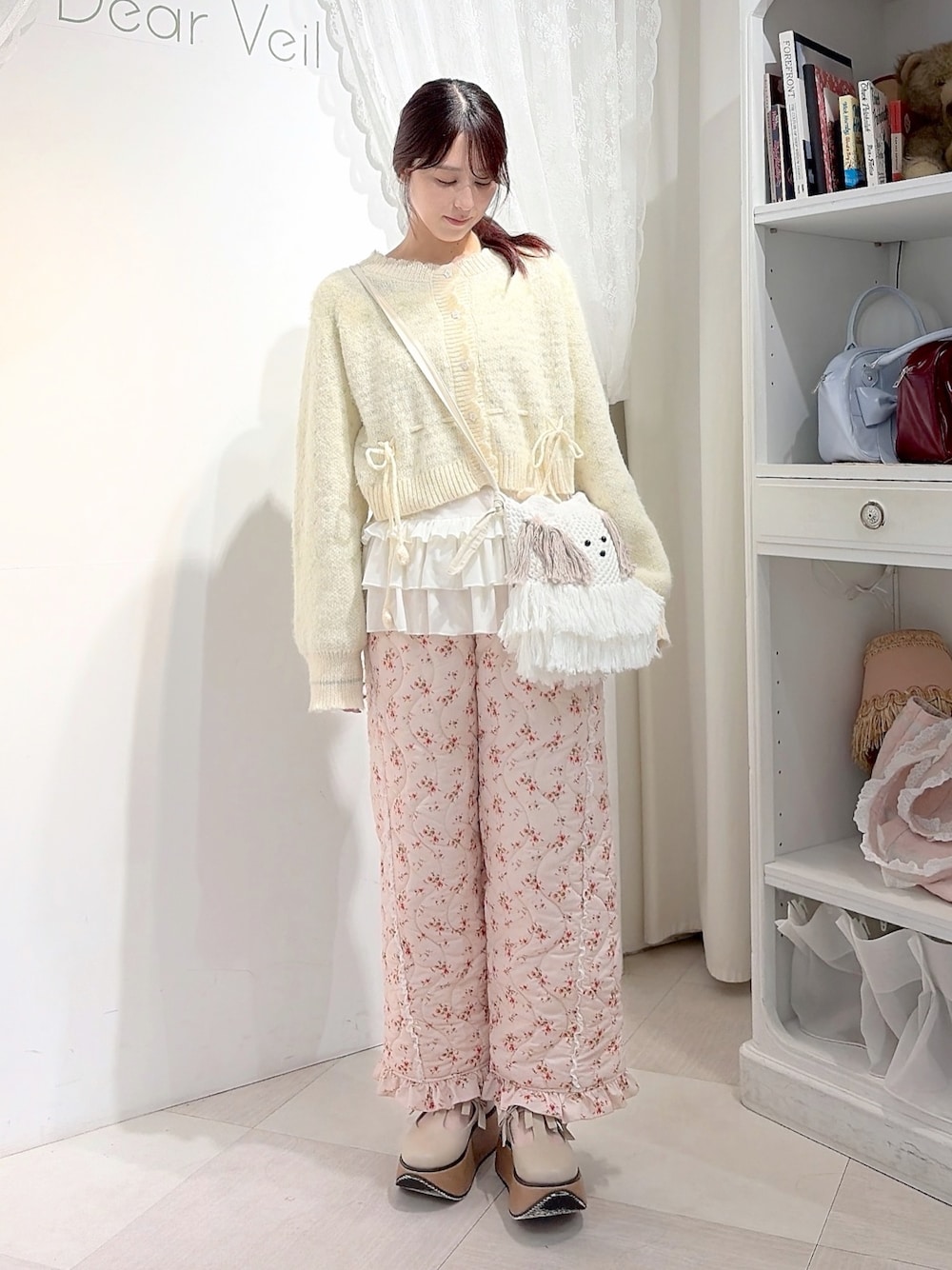 ホワイト系のカーディガン/ボレロ、ホワイト系のTシャツ/カットソー、ベージュ系のショルダーバッグを着用したレディースの秋コーディネートの1枚目の写真