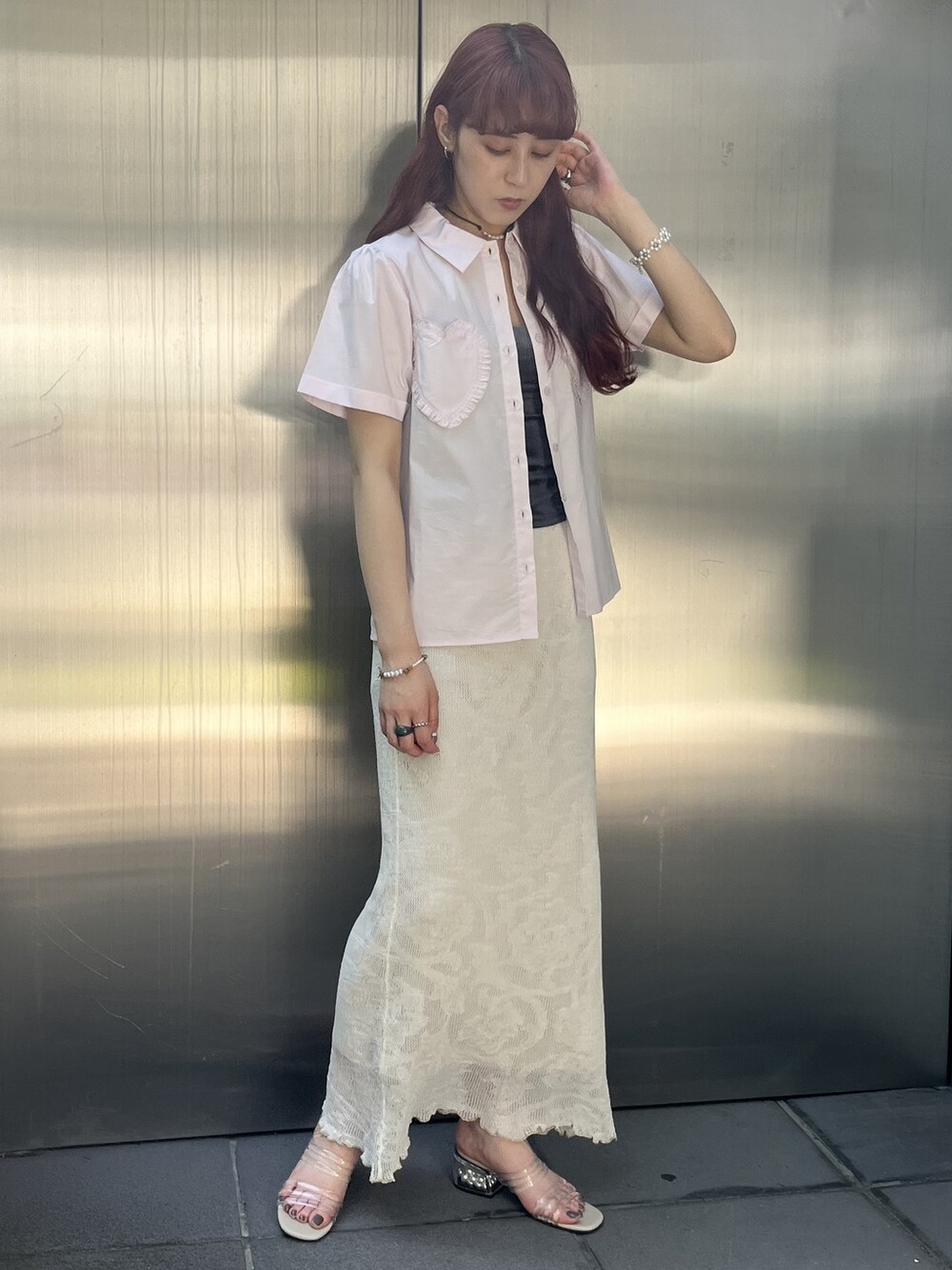 ピンク系のシャツ/ブラウス、ホワイト系のスカート、ベージュ系のサンダルを着用したレディースの夏コーディネートの1枚目の写真