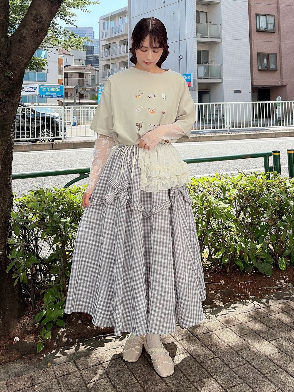グレー系のスカート、ホワイト系のバレエシューズ、グリーン系のTシャツ/カットソーを着用したレディースの春コーディネートの1枚目の写真