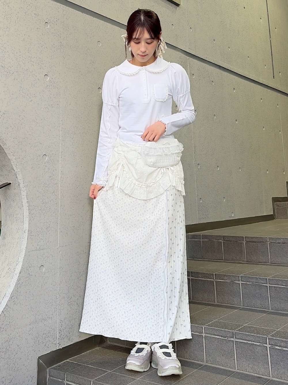 ホワイト系のポロシャツ、ホワイト系のボディバッグ/ウエストポーチ、ホワイト系のスカートを着用したレディースの冬コーディネートの1枚目の写真