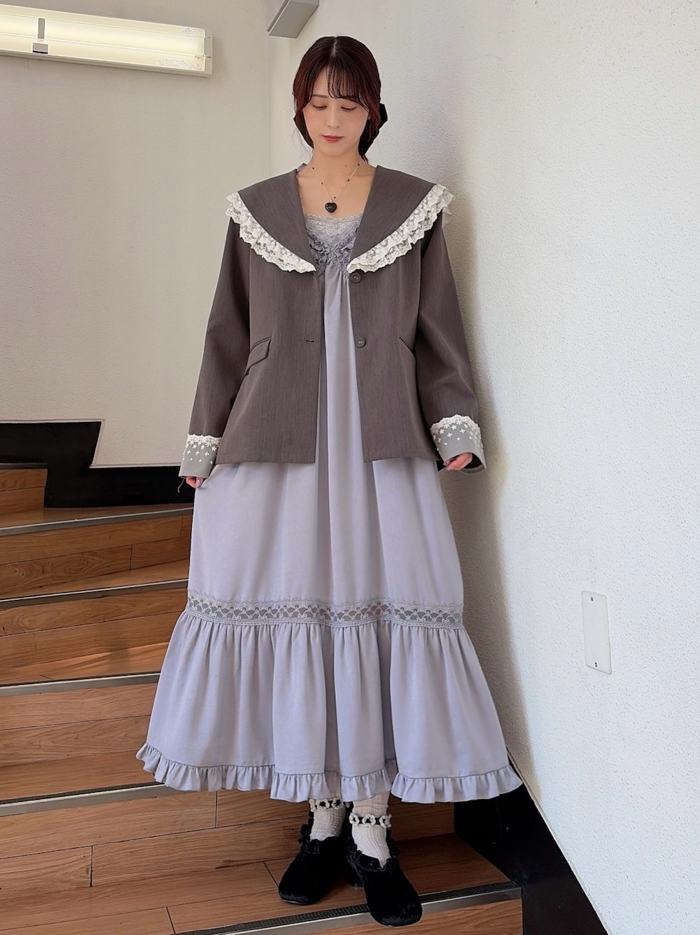 ブルー系のワンピース、ブラック系のパンプス、グレー系のテーラードジャケットを着用したレディースの春コーディネートの1枚目の写真