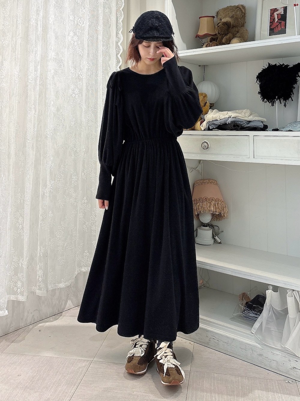ブラック系のワンピース、ブラウン系のスニーカー、ブラック系のキャップを着用したレディースの秋コーディネートの1枚目の写真
