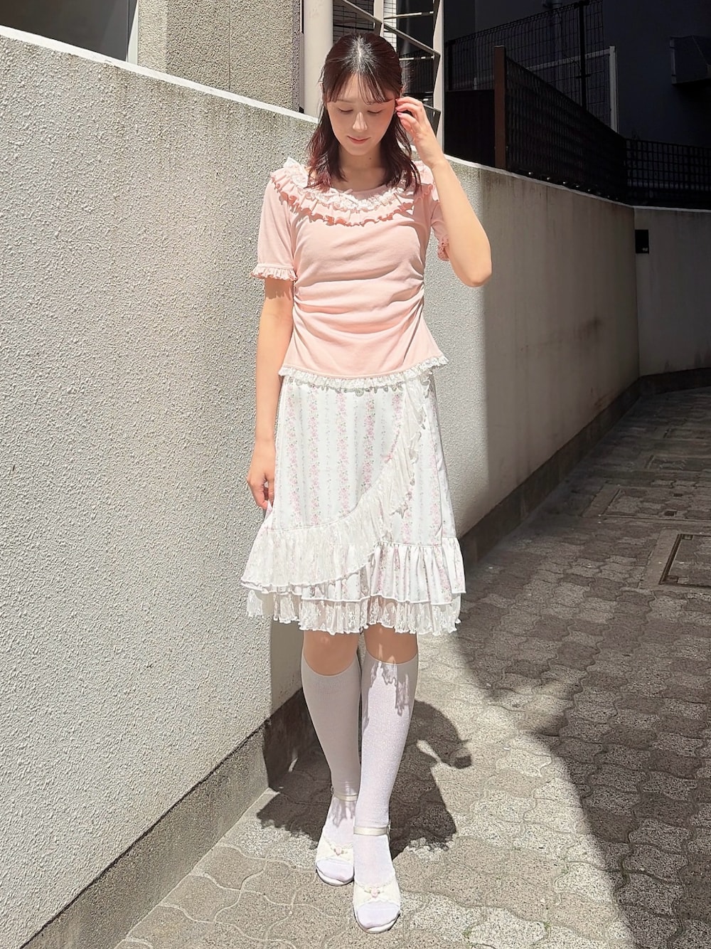 ピンク系のTシャツ/カットソー、ピンク系のスカート、ホワイト系のサンダルを着用したレディースの春コーディネートの1枚目の写真