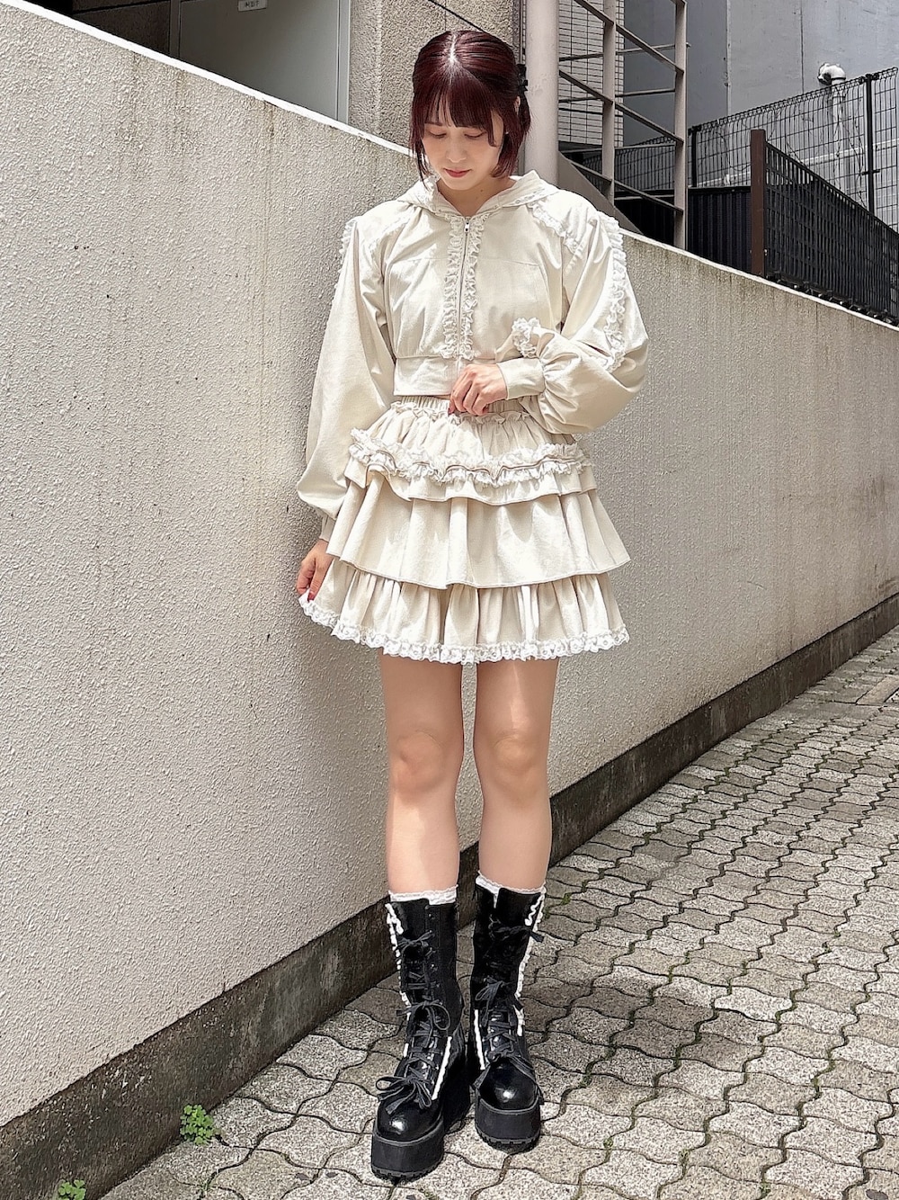 ホワイト系のパーカー、ホワイト系のスカート、ブラック系のブーツを着用したレディースの夏コーディネートの1枚目の写真
