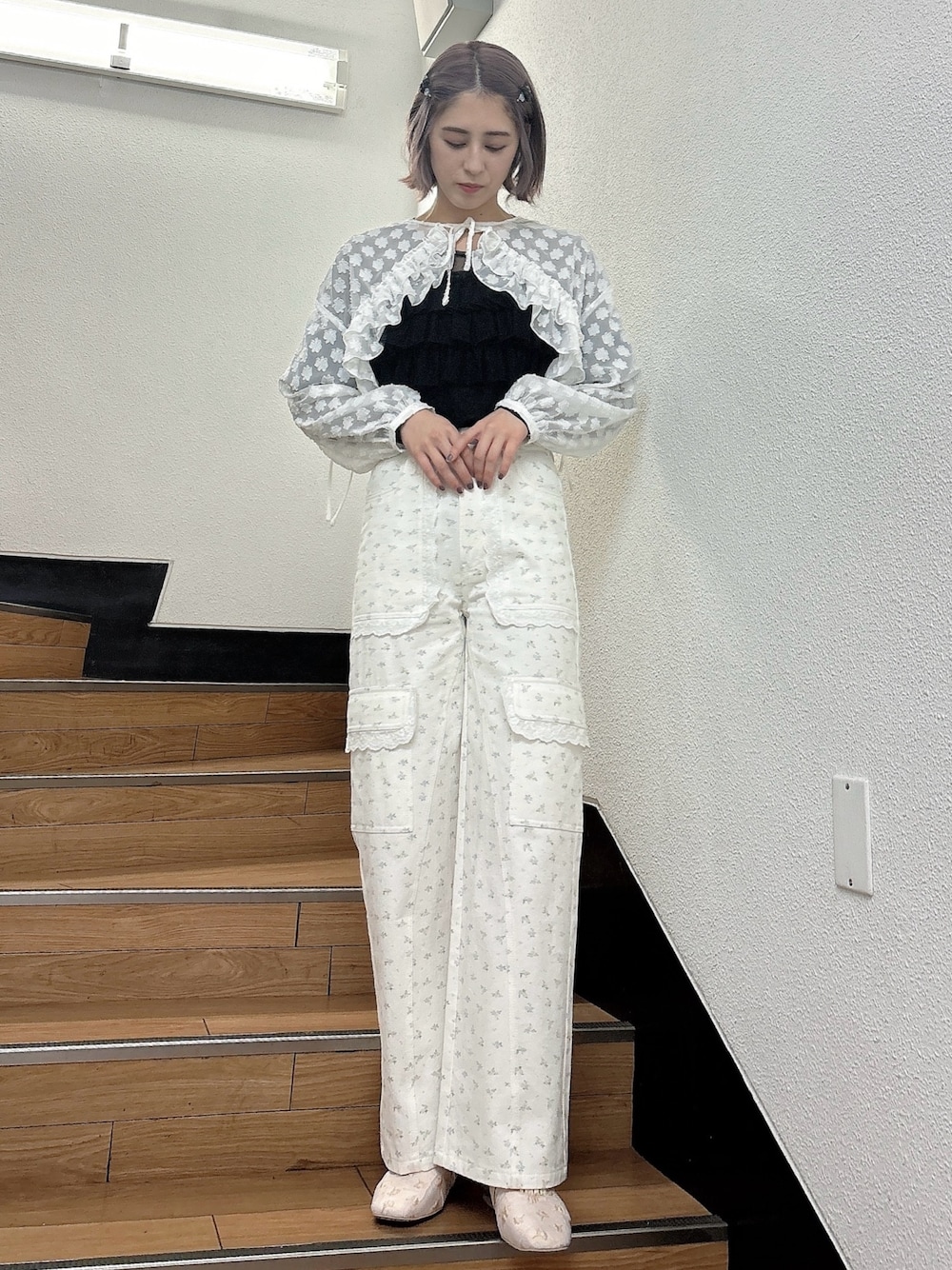 ブラック系のTシャツ/カットソー、ホワイト系のシャツ/ブラウス、ホワイト系のカーゴパンツを着用したレディースの春コーディネートの1枚目の写真