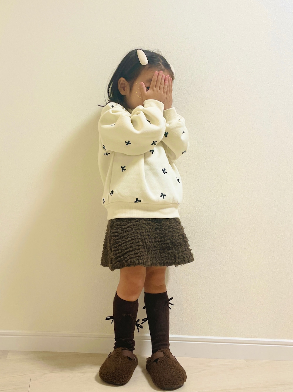 ホワイト系のスウェット、ブラウン系のその他ベビーウェアを着用したキッズの秋コーディネートの1枚目の写真