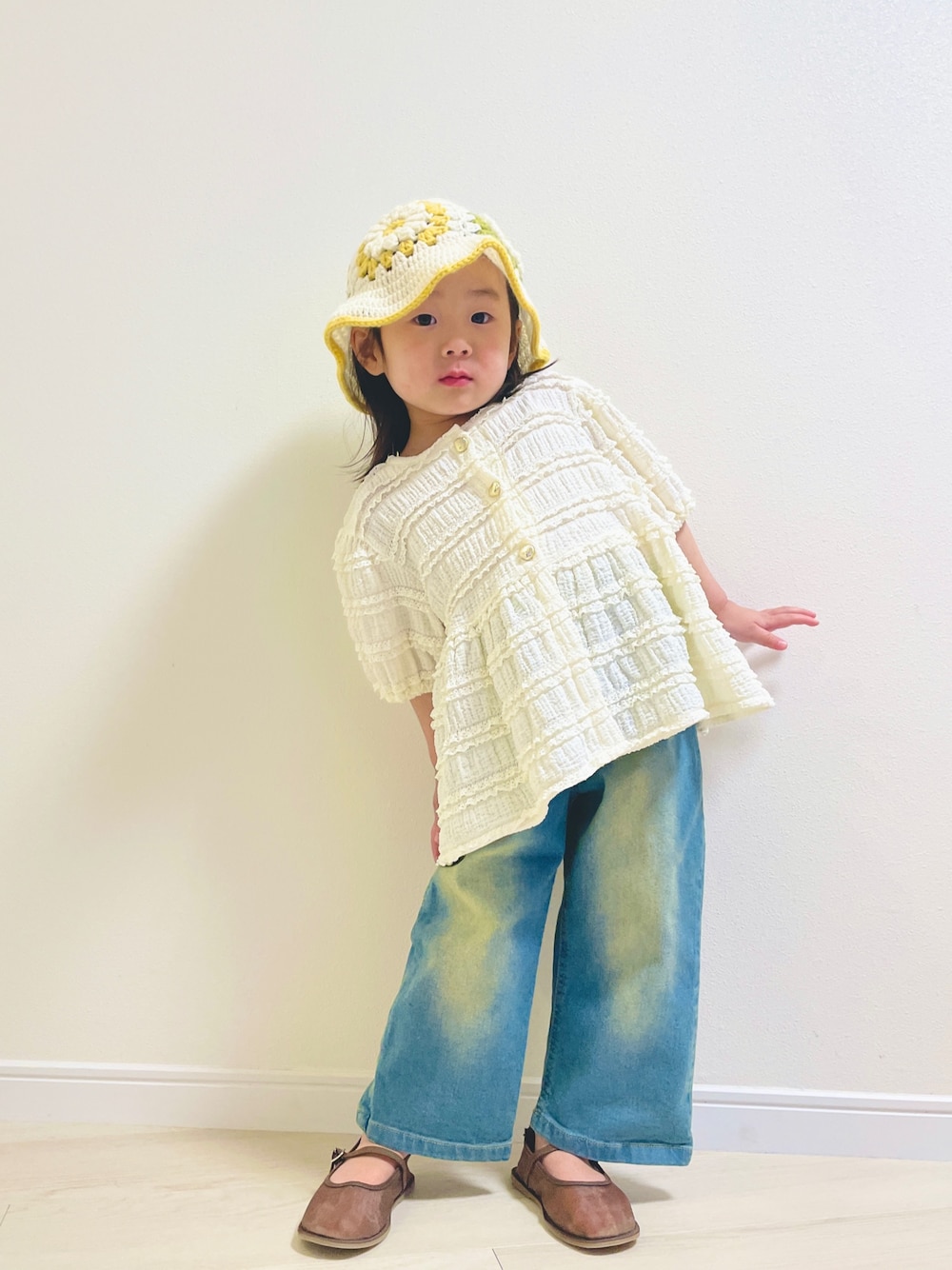 ブルー系のデニムパンツ、ブラウン系のパンプス、ホワイト系のその他ベビーウェアを着用したキッズの春コーディネートの1枚目の写真