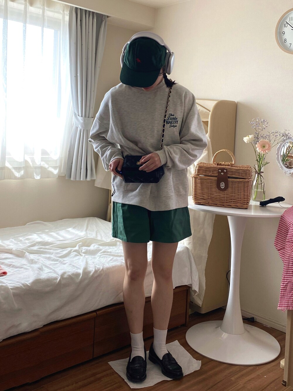 グリーン系のデニムパンツ、ブラック系のローファー、ブラック系のショルダーバッグを着用したレディースの春コーディネートの1枚目の写真