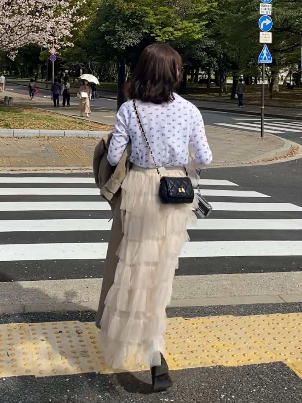 ホワイト系のTシャツ/カットソー、ホワイト系のスカート、ブラック系のショルダーバッグを着用したレディースの春コーディネートの1枚目の写真