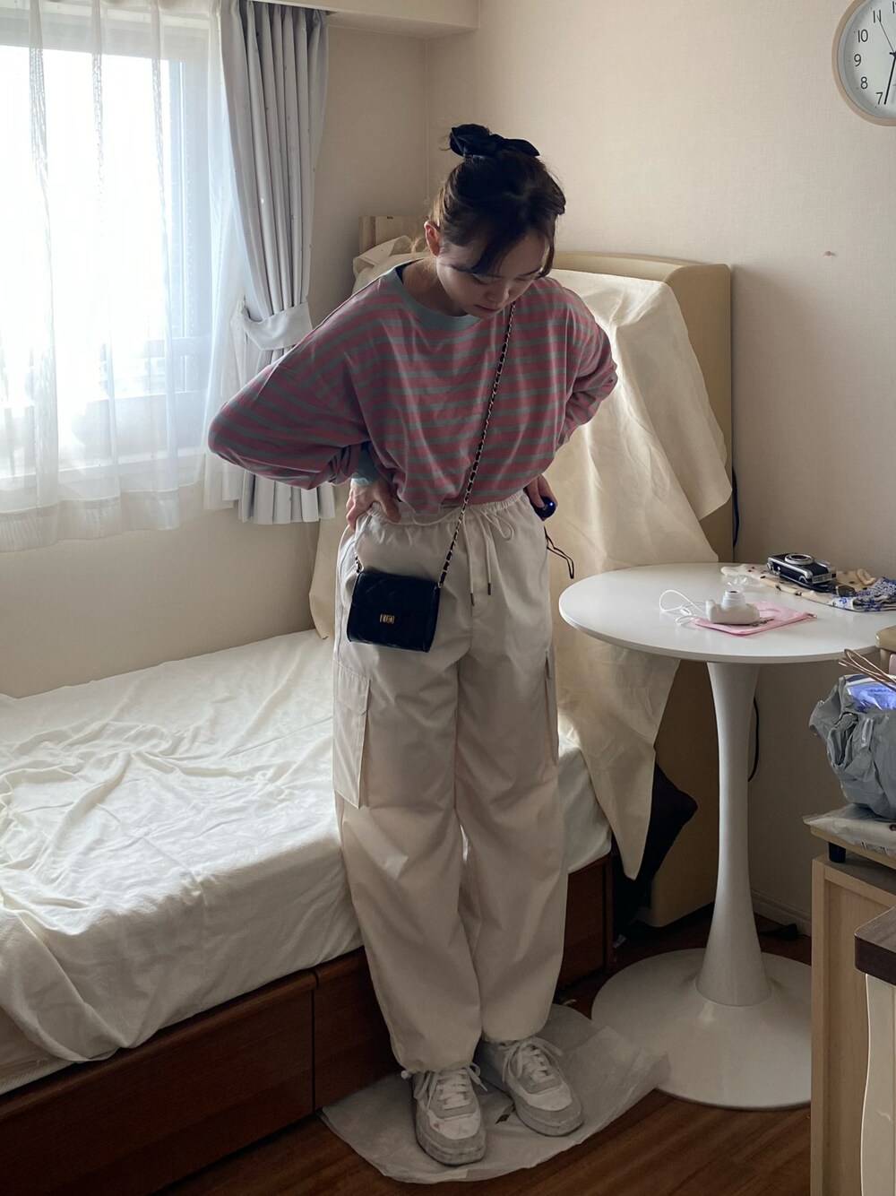 ピンク系のTシャツ/カットソー、ホワイト系のカーゴパンツ、ブラック系のトートバッグを着用したレディースの春コーディネートの1枚目の写真