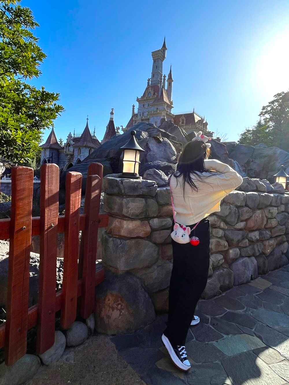 ブラック系のスラックス、ホワイト系のニット/セーターを着用したレディースの冬コーディネートの1枚目の写真