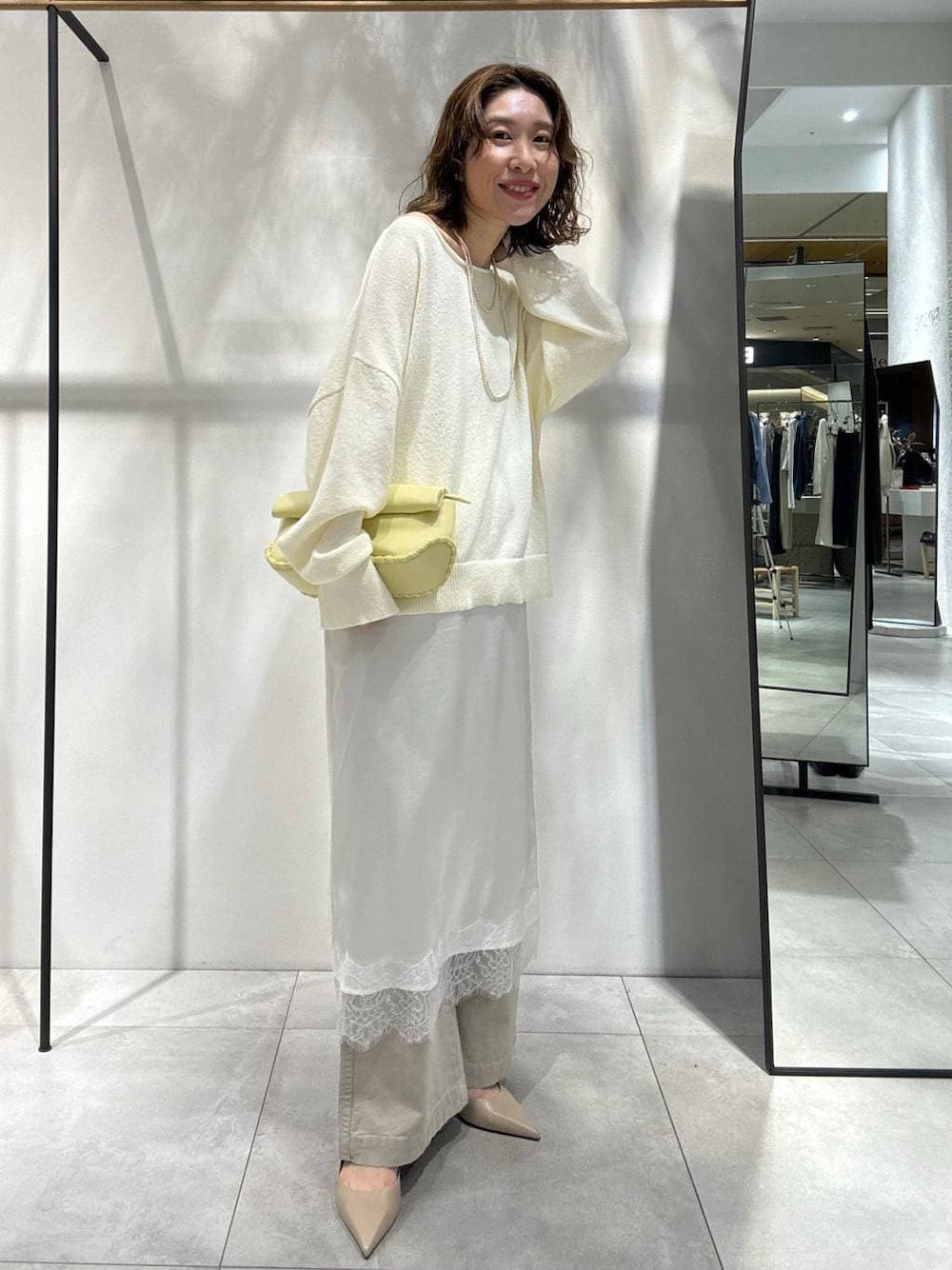 イエロー系のハンドバッグ、ベージュ系のその他パンツ、ベージュ系のトレンチコートを着用したレディースの春コーディネートの1枚目の写真
