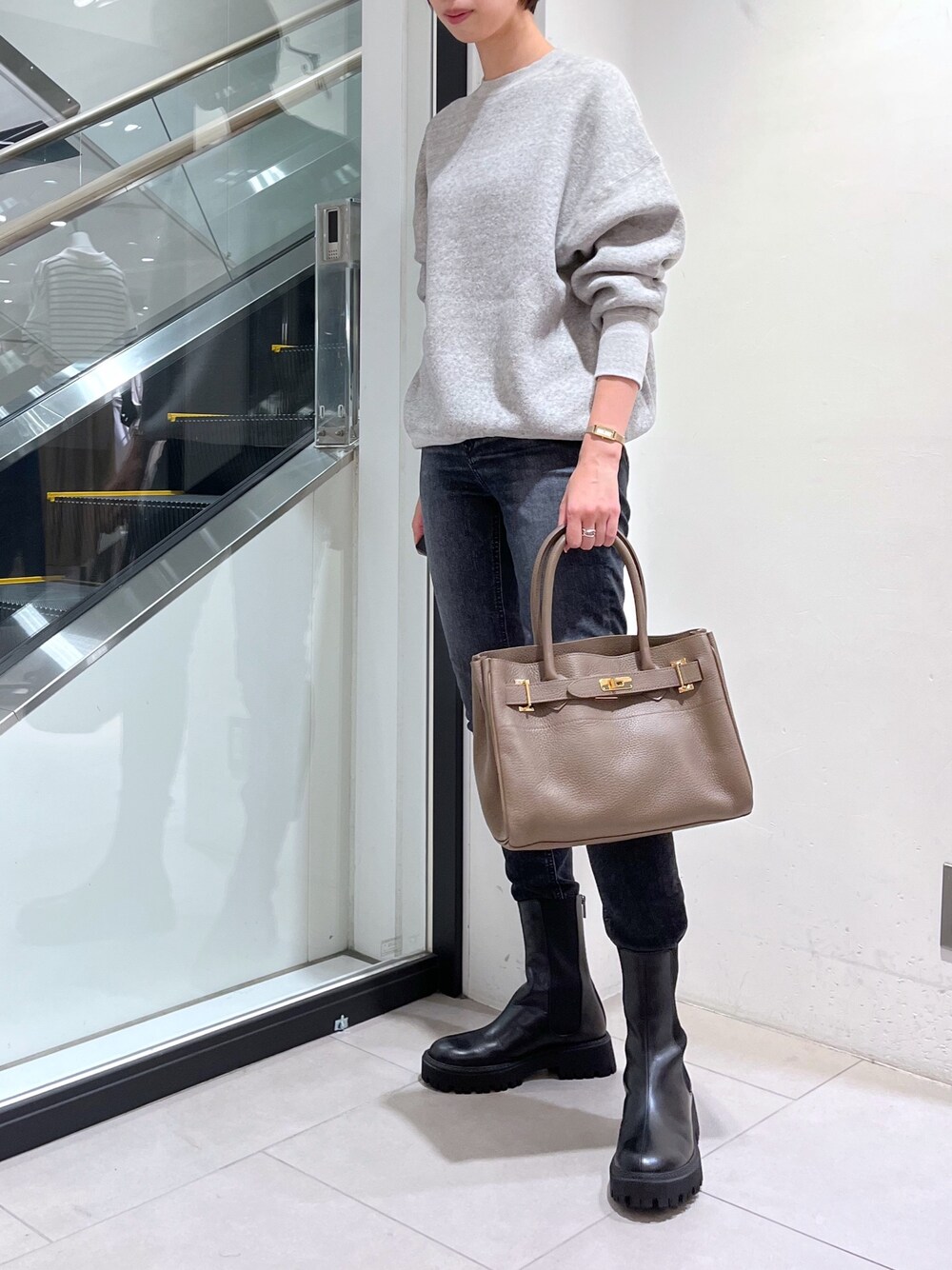 ブラック系のデニムパンツ、ベージュ系のトートバッグ、ブラック系のその他シューズを着用したレディースの秋コーディネートの1枚目の写真