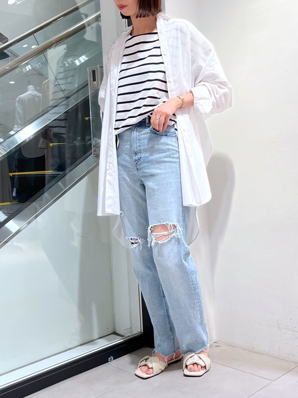 ブルー系のデニムパンツ、ホワイト系のシャツ/ブラウス、ホワイト系のTシャツ/カットソーを着用したレディースの秋コーディネートの1枚目の写真