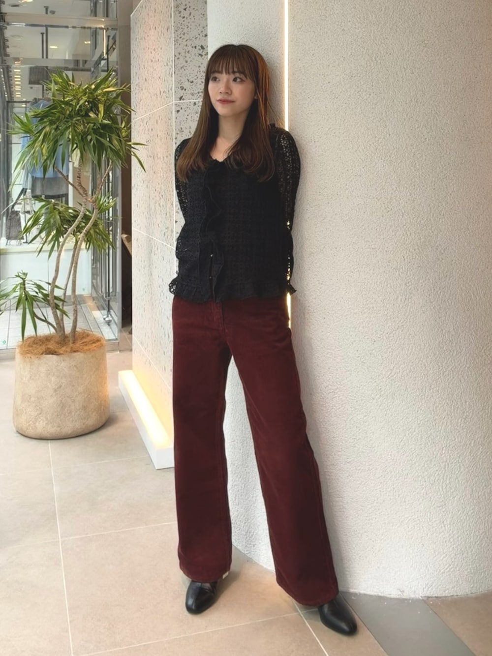 ブラック系のカーディガン/ボレロ、レッド系のその他パンツ、ブラック系のブーツを着用したレディースの秋コーディネートの1枚目の写真