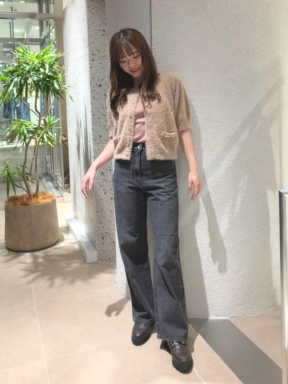 ベージュ系のニット/セーター、ブラック系のデニムパンツ、ブラウン系のローファーを着用したレディースの夏コーディネートの1枚目の写真