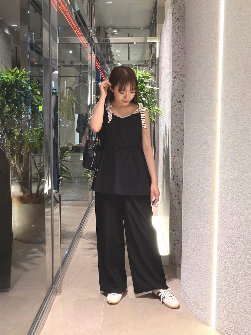 ホワイト系のTシャツ/カットソー、ホワイト系のスニーカー、ブラック系のボストンバッグを着用したレディースの夏コーディネートの1枚目の写真