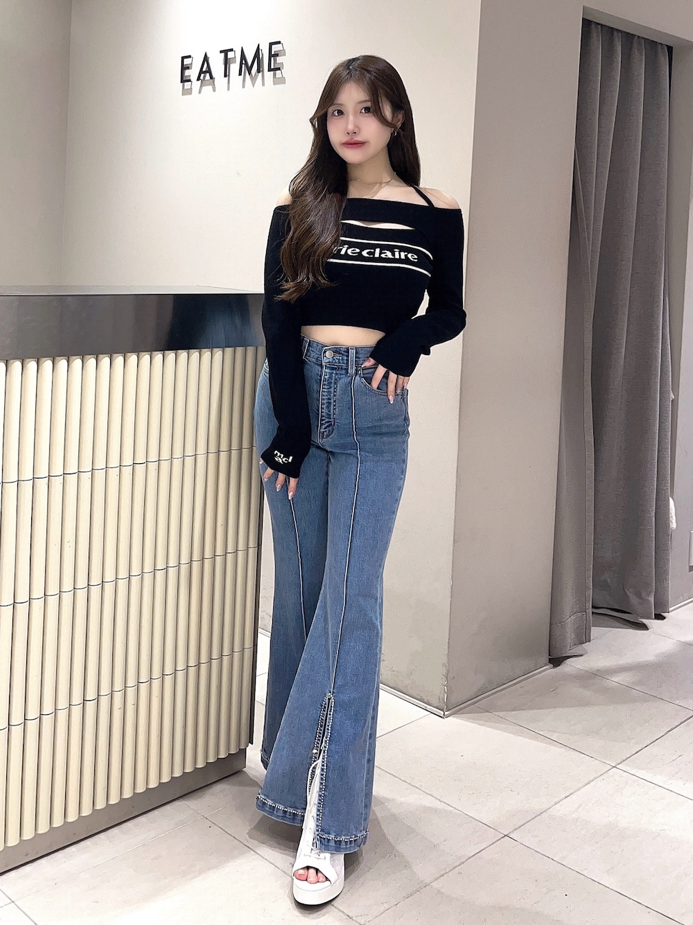 ホワイト系のブーツ、ブルー系のデニムパンツ、ブラック系のニット/セーターを着用したレディースの春コーディネートの1枚目の写真