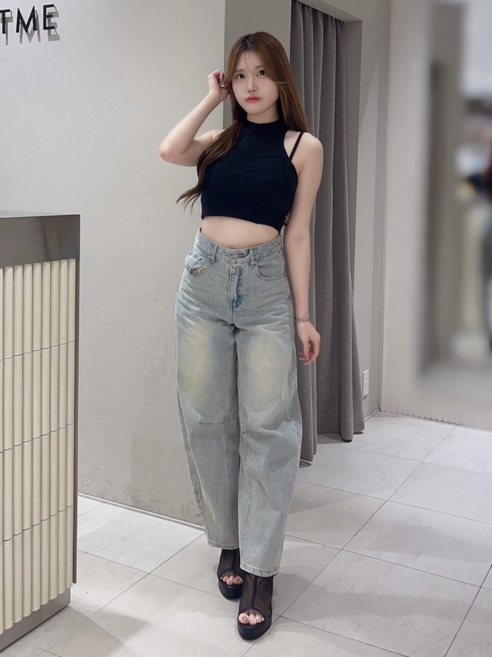 ブラック系のタンクトップ、ブルー系のデニムパンツ、ブラック系のサンダルを着用したレディースの夏コーディネートの1枚目の写真