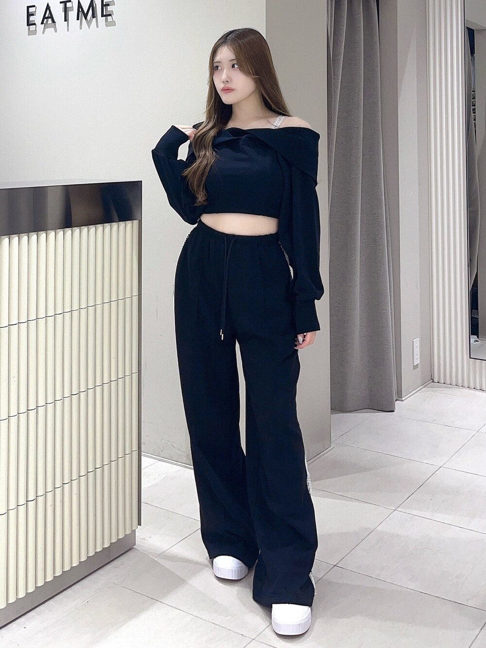 ブラック系のTシャツ/カットソー、ブラック系のスウェットパンツ、ホワイト系のスニーカーを着用したレディースの夏コーディネートの1枚目の写真