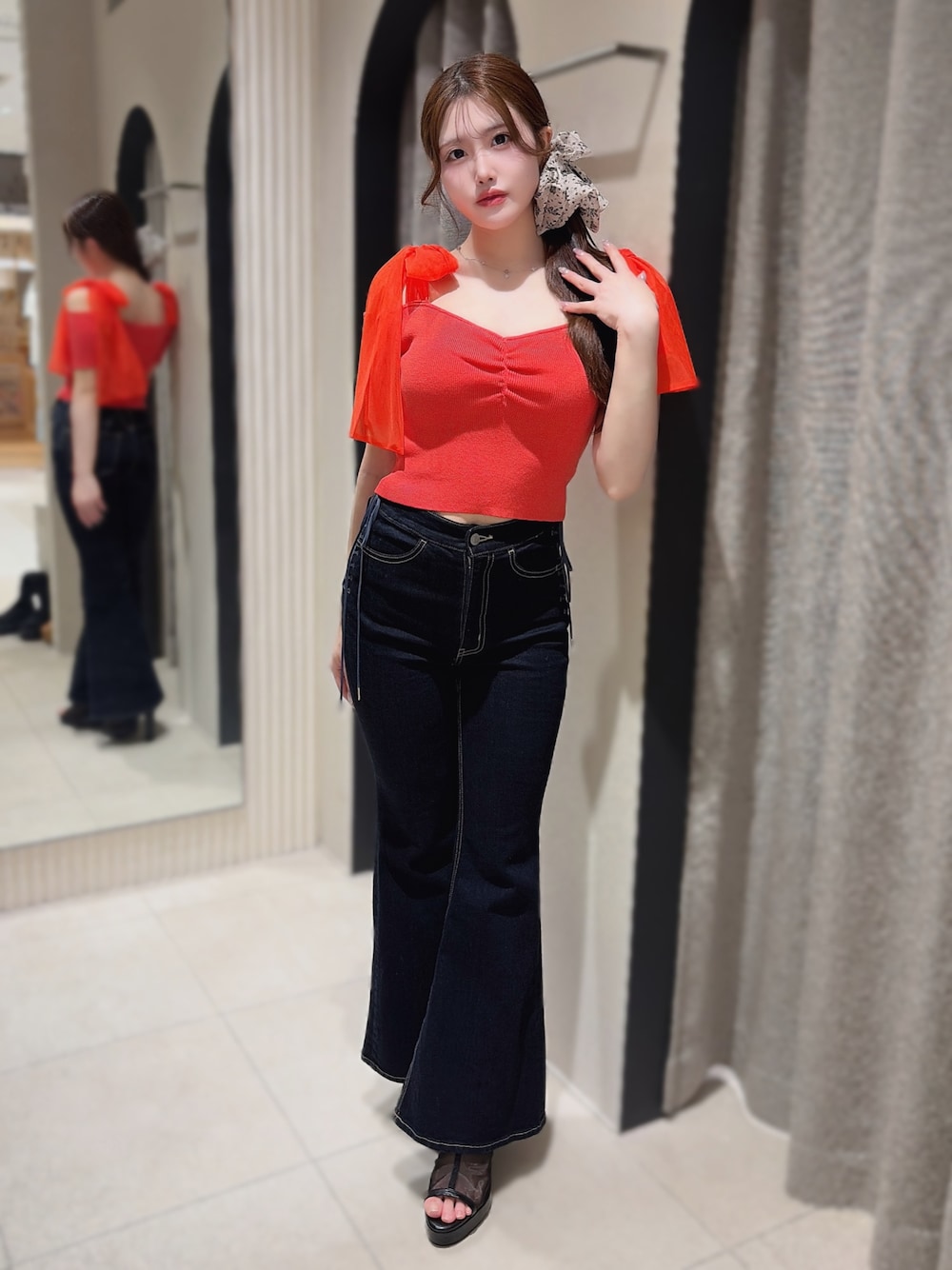 オレンジ系のTシャツ/カットソー、ブルー系のデニムパンツ、ブラック系のサンダルを着用したレディースの春コーディネートの1枚目の写真