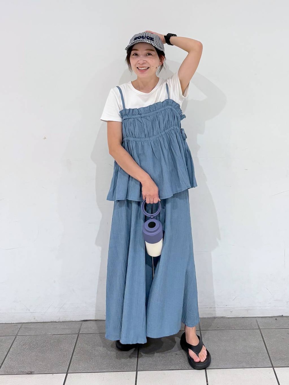 ブルー系のキャミソール、ホワイト系のTシャツ/カットソー、ブルー系のアウトドアグッズを着用したレディースの夏コーディネートの1枚目の写真