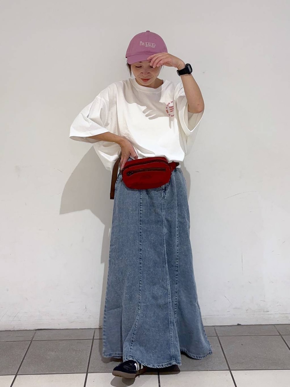 レッド系のボディバッグ/ウエストポーチ、ホワイト系のTシャツ/カットソー、ブルー系のデニムスカートを着用したレディースの夏コーディネートの1枚目の写真