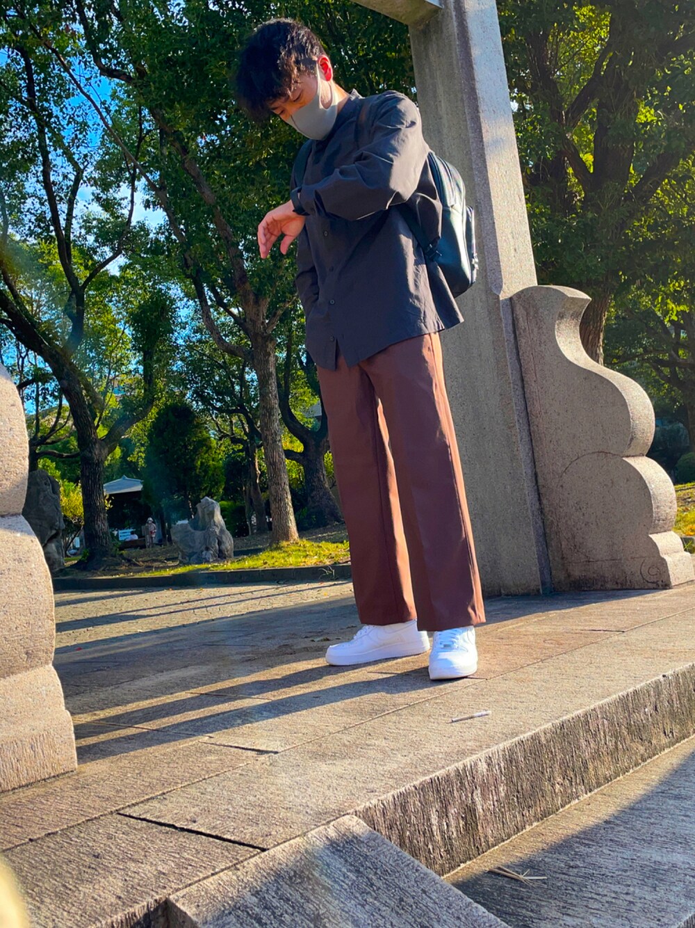 ブラウン系のパンツ、ホワイト系のスニーカー、ブラック系のシャツ/ブラウスを着用したメンズの秋コーディネートの1枚目の写真