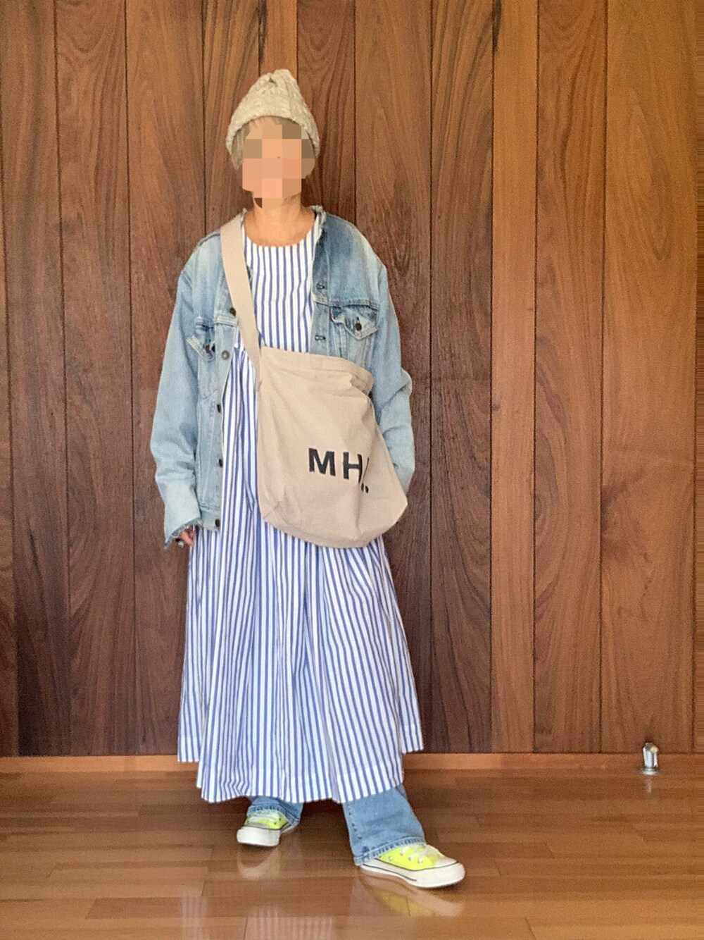 ブルー系のデニムジャケット、ブルー系のワンピース、イエロー系のスニーカーを着用したレディースの冬コーディネートの1枚目の写真