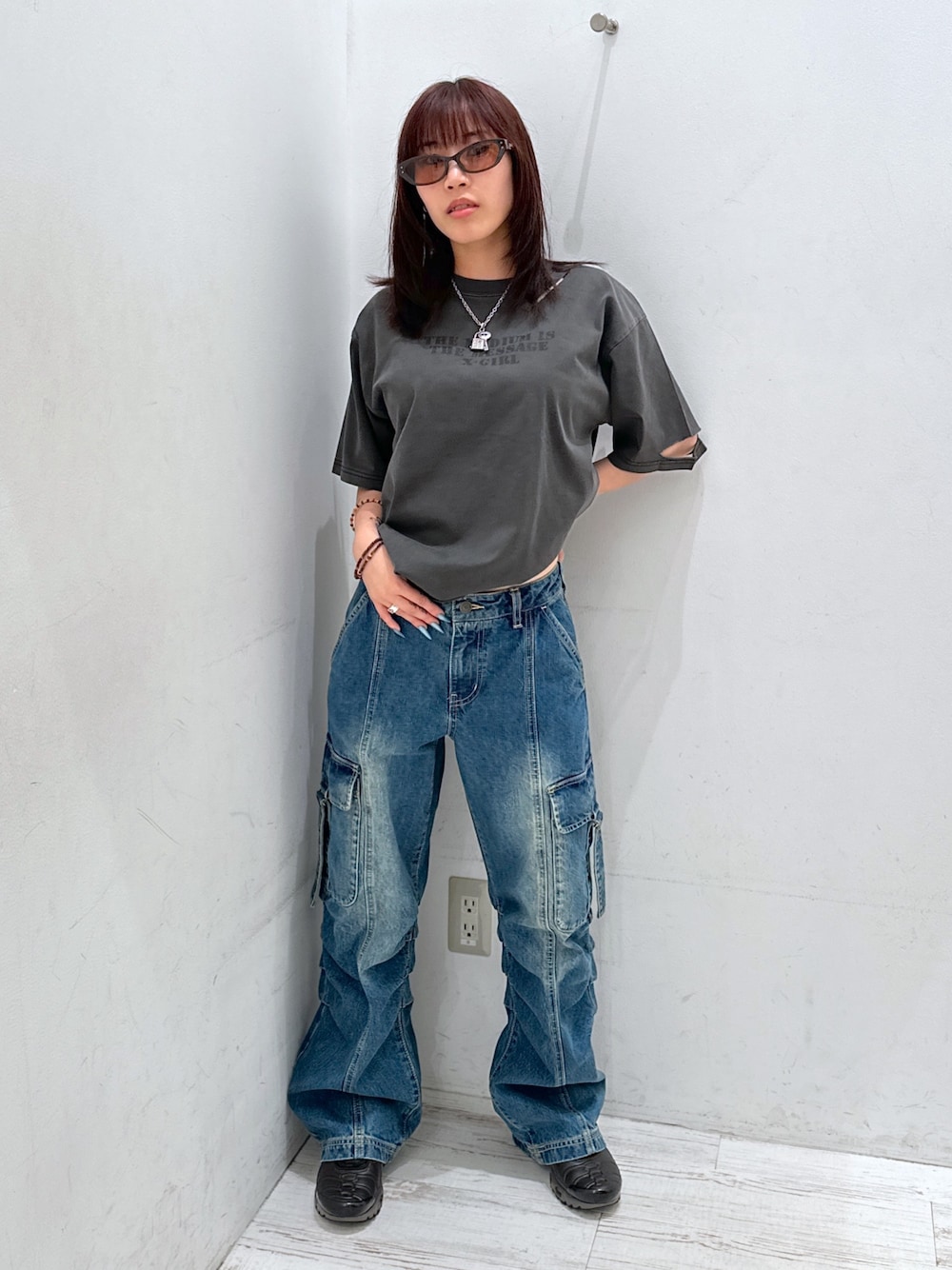 ブルー系のデニムパンツ、ブラック系のTシャツ/カットソー、ブラウン系のサングラスを着用したレディースの夏コーディネートの1枚目の写真