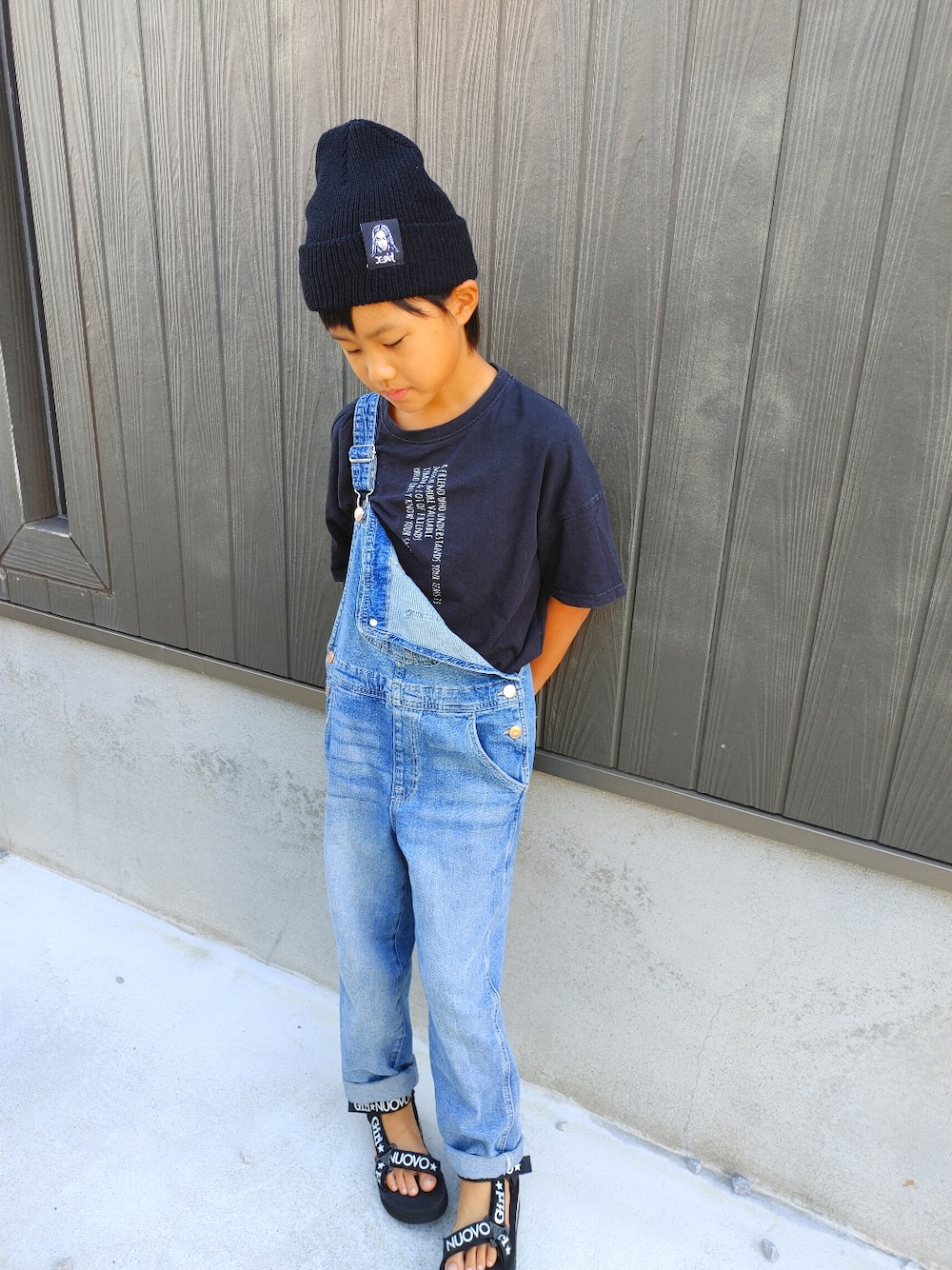 ブルー系のつなぎ/オールインワン、ブラック系のニットキャップ/ビーニーを着用したキッズの春コーディネートの2枚目の写真