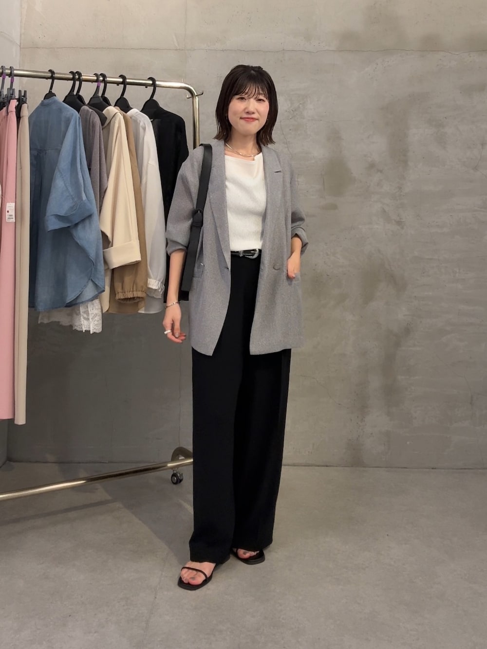 グレー系のテーラードジャケット、ホワイト系のTシャツ/カットソー、ブラック系のスラックスを着用したレディースの春コーディネートの1枚目の写真