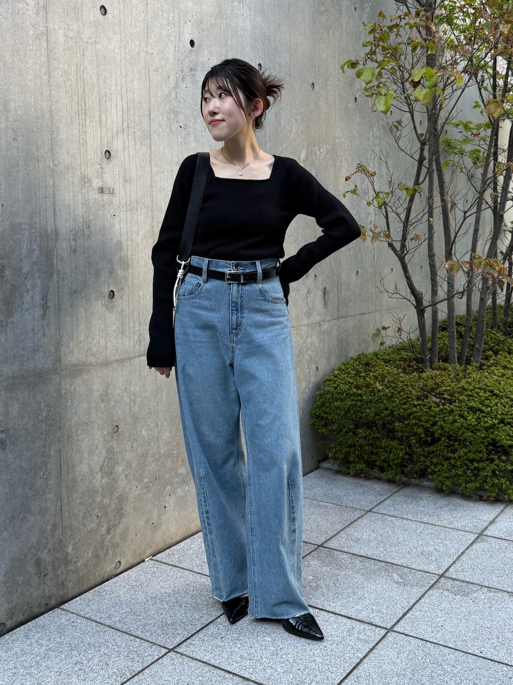 ブルー系のデニムパンツ、ブラック系のニット/セーター、ブラック系のパンプスを着用したレディースの秋コーディネートの1枚目の写真