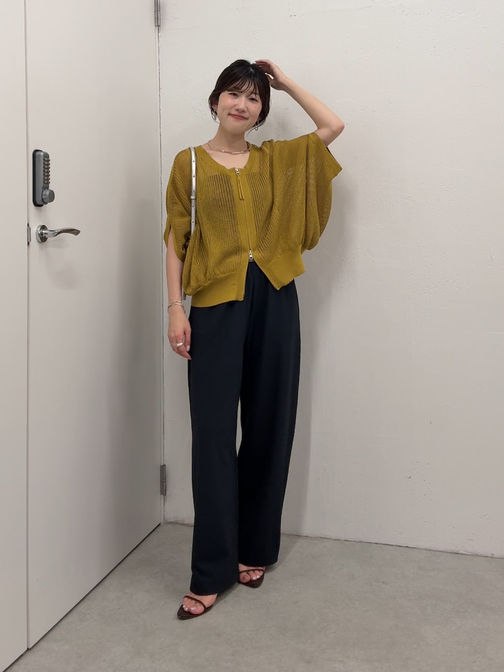 イエロー系のカーディガン/ボレロ、ブラック系のその他パンツ、シルバー系のショルダーバッグを着用したレディースの夏コーディネートの1枚目の写真