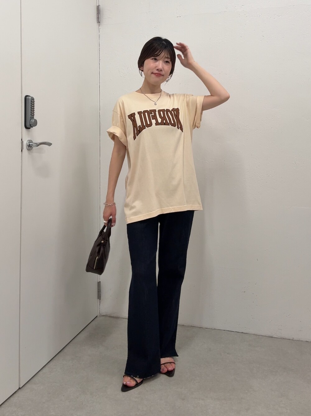 ベージュ系のTシャツ/カットソー、ブルー系のデニムパンツ、ブラウン系のショルダーバッグを着用したレディースの夏コーディネートの1枚目の写真