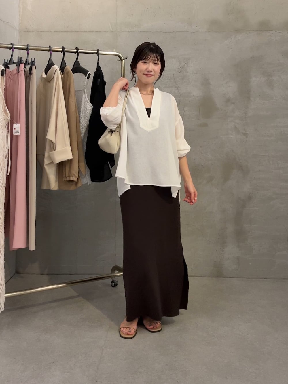 ホワイト系のシャツ/ブラウス、ブラウン系のワンピース、ホワイト系のショルダーバッグを着用したレディースの春コーディネートの1枚目の写真