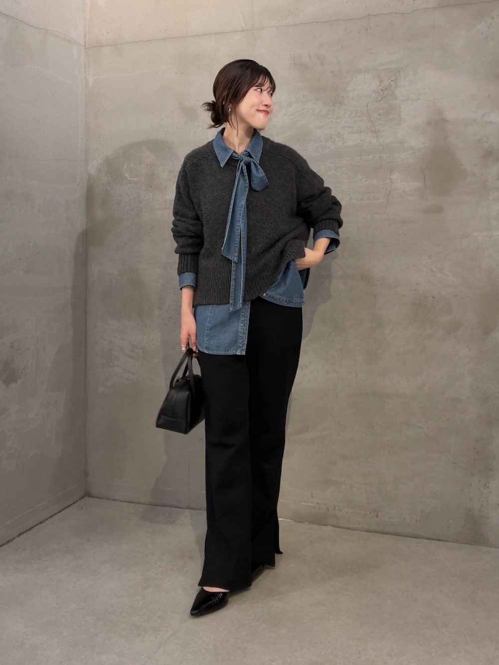 グレー系のニット/セーター、ブルー系のシャツ/ブラウス、ブラック系のその他パンツを着用したレディースの秋コーディネートの1枚目の写真