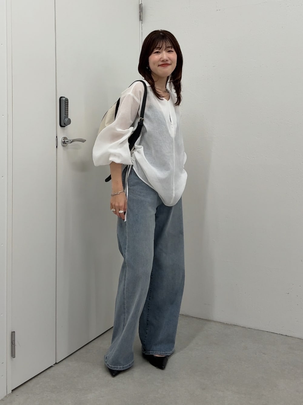 ホワイト系のシャツ/ブラウス、ブルー系のデニムパンツ、ブラック系のショルダーバッグを着用したレディースの春コーディネートの1枚目の写真