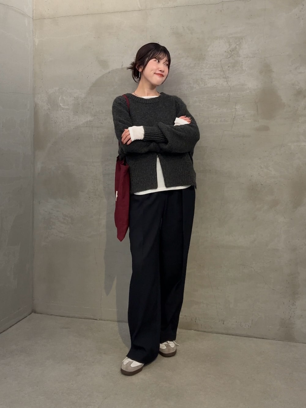 グレー系のニット/セーター、ホワイト系のTシャツ/カットソー、ブルー系のスラックスを着用したレディースの冬コーディネートの1枚目の写真