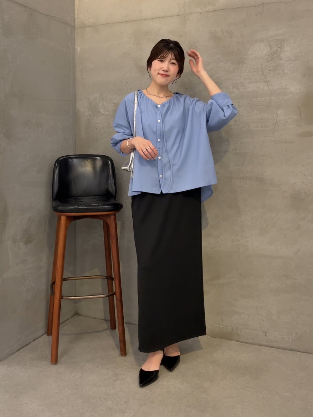 ブラック系のスカート、ブルー系のシャツ/ブラウス、シルバー系のショルダーバッグを着用したレディースの夏コーディネートの1枚目の写真