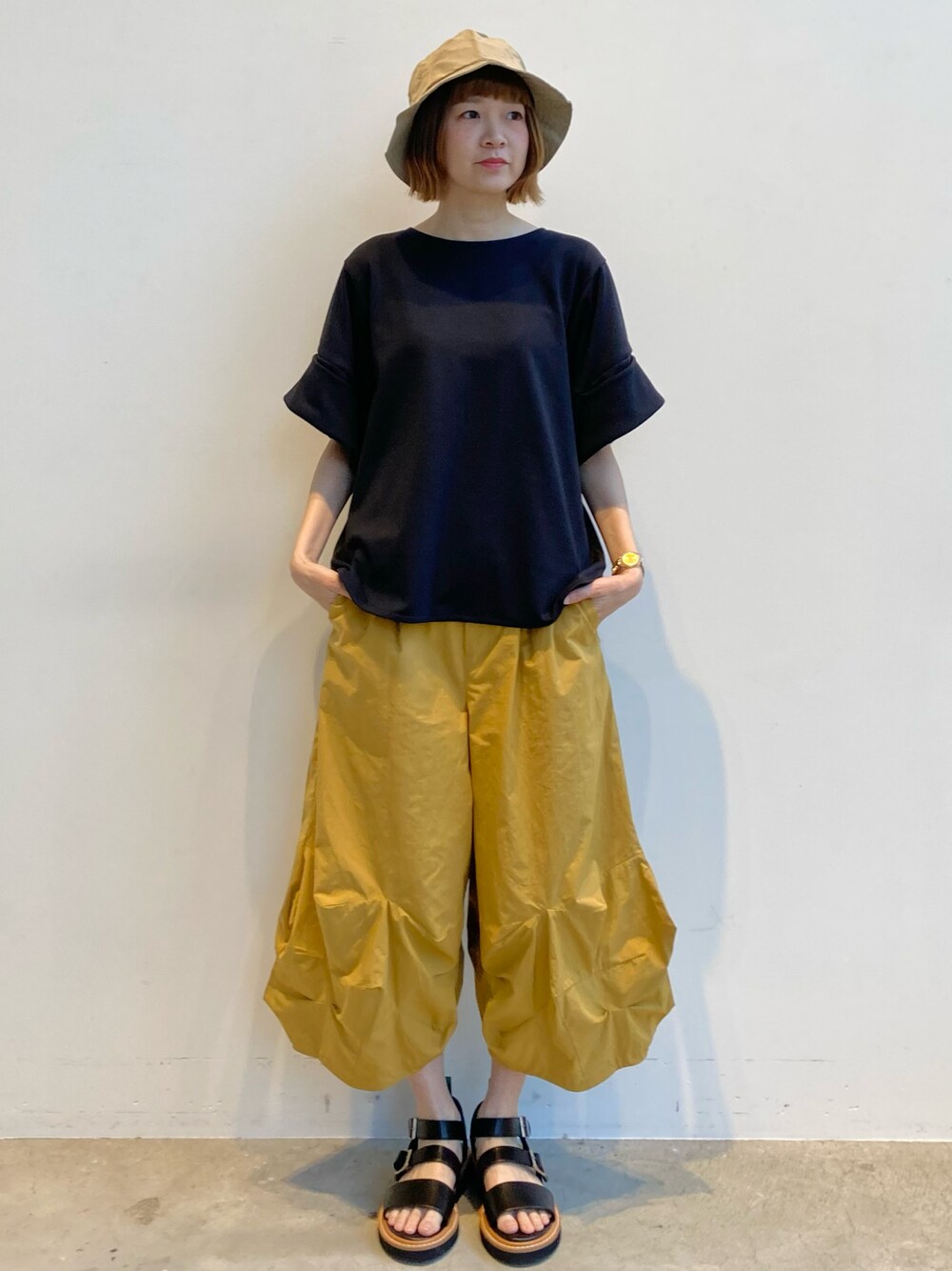 ブラック系のTシャツ/カットソー、イエロー系のその他パンツ、ブラック系のサンダルを着用したレディースの夏コーディネートの1枚目の写真