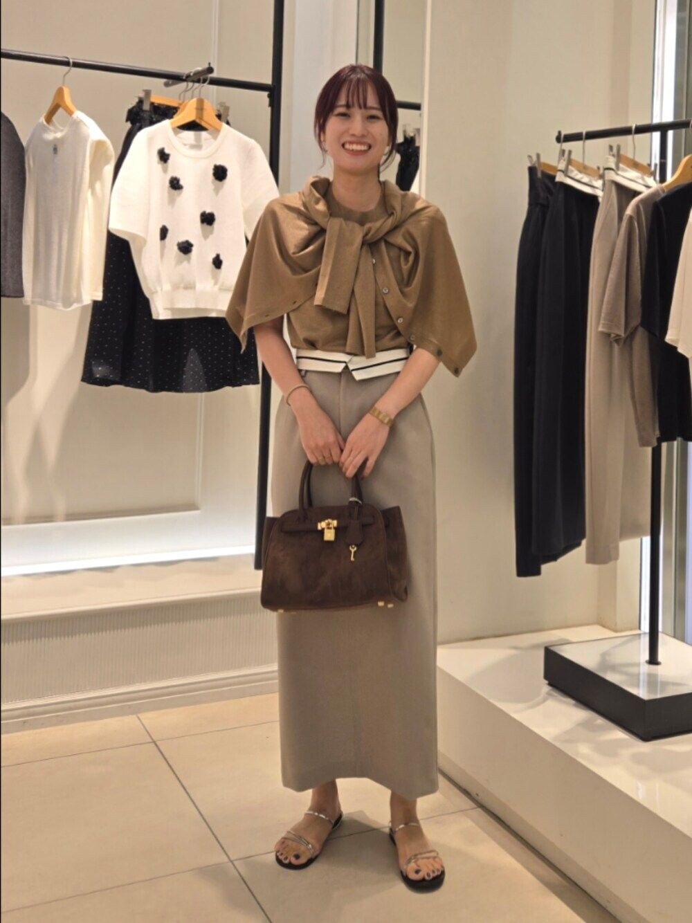 イエロー系のニット/セーター、イエロー系のカーディガン/ボレロ、グリーン系のスカートを着用したレディースの夏コーディネートの1枚目の写真