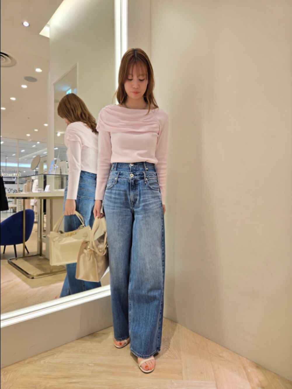 ピンク系のニット/セーター、ベージュ系のトートバッグ、グレー系のネックレスを着用したレディースの春コーディネートの1枚目の写真