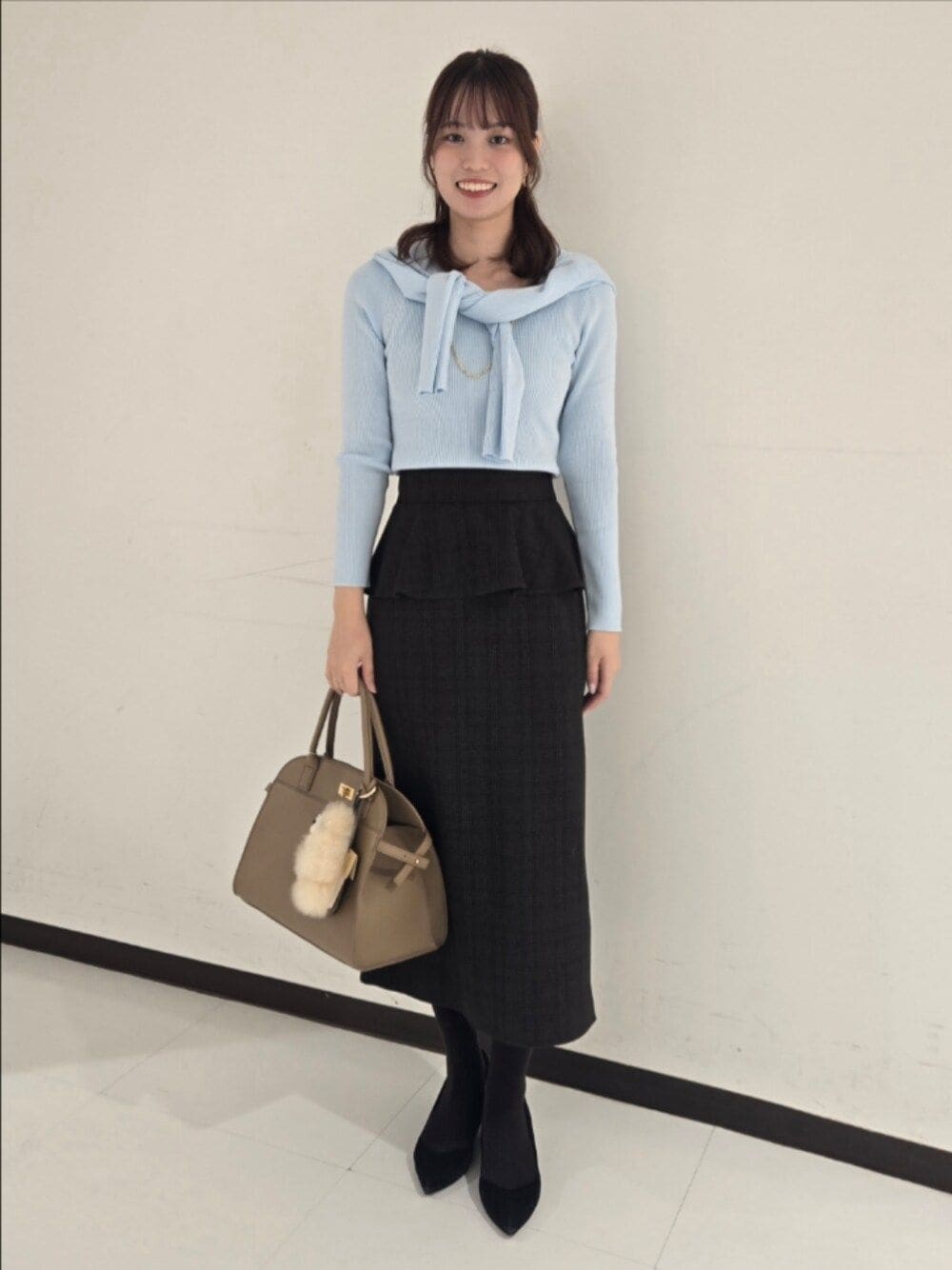 ブルー系のカーディガン/ボレロ、ブルー系のニット/セーター、ベージュ系のスカートを着用したレディースの秋コーディネートの1枚目の写真
