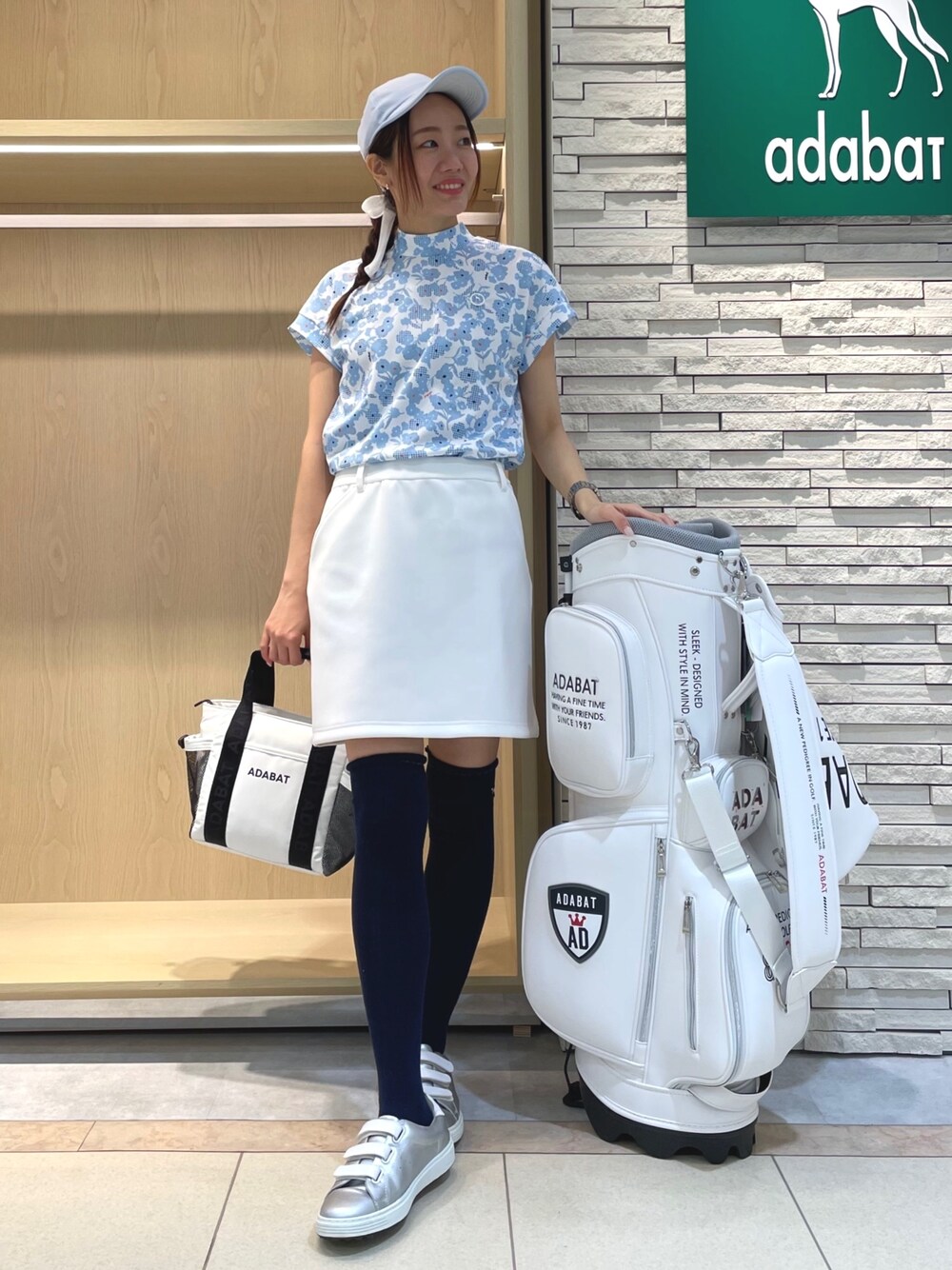 ブルー系のTシャツ/カットソー、ホワイト系のスカート、ホワイト系のトートバッグを着用したレディースの春コーディネートの1枚目の写真