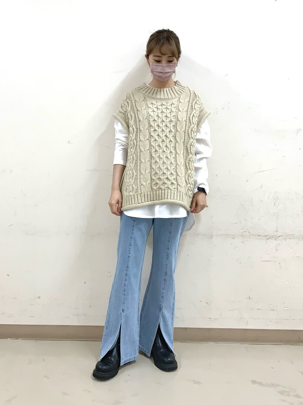 ブルー系のデニムパンツ、ベージュ系のベスト、ホワイト系のTシャツ/カットソーを着用したレディースの冬コーディネートの1枚目の写真