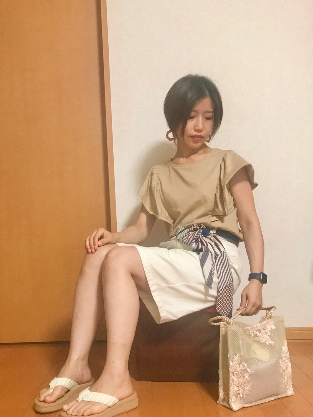 ベージュ系のサンダル、ホワイト系のトートバッグ、ホワイト系のパンツを着用したレディースの夏コーディネートの1枚目の写真