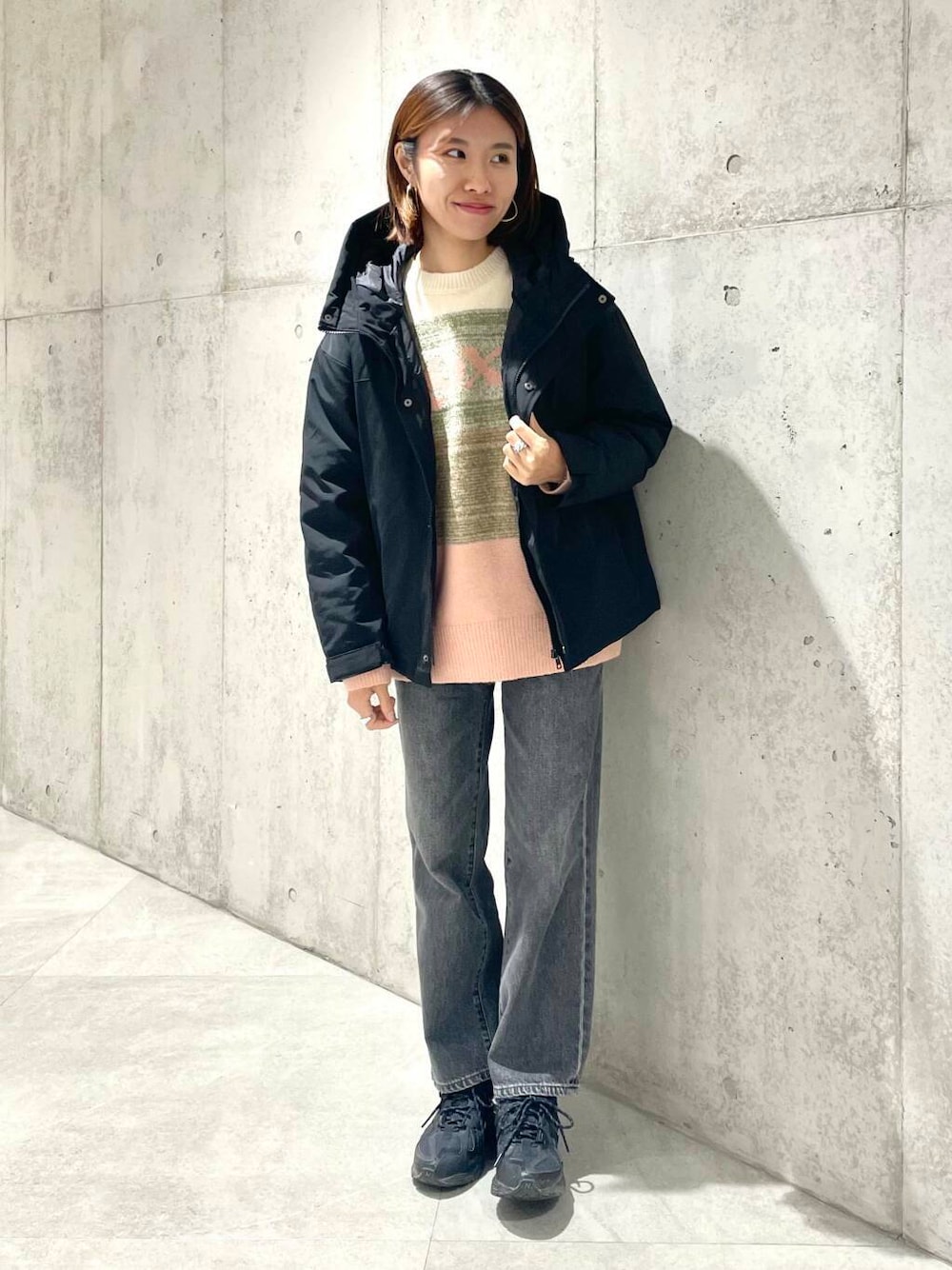ブラック系のデニムパンツ、ブラック系のダウンジャケット/コート、ピンク系のニット/セーターを着用したレディースの秋コーディネートの1枚目の写真