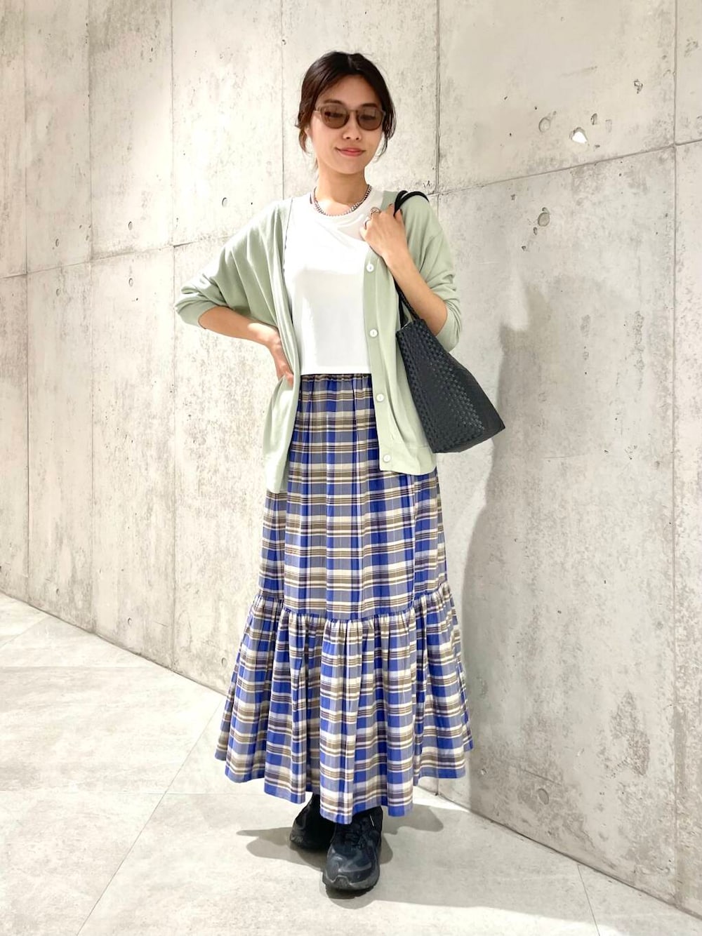 グリーン系のカーディガン/ボレロ、ホワイト系のTシャツ/カットソー、ブラック系のトートバッグを着用したレディースの春コーディネートの1枚目の写真