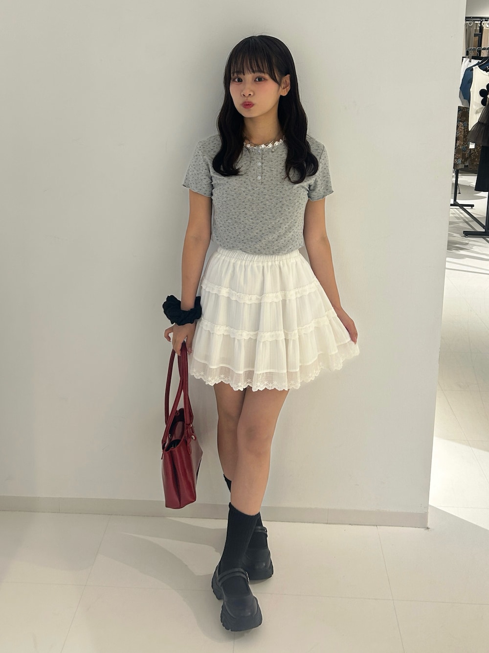 グレー系のTシャツ/カットソー、ホワイト系のスカートを着用したレディースの夏コーディネートの1枚目の写真